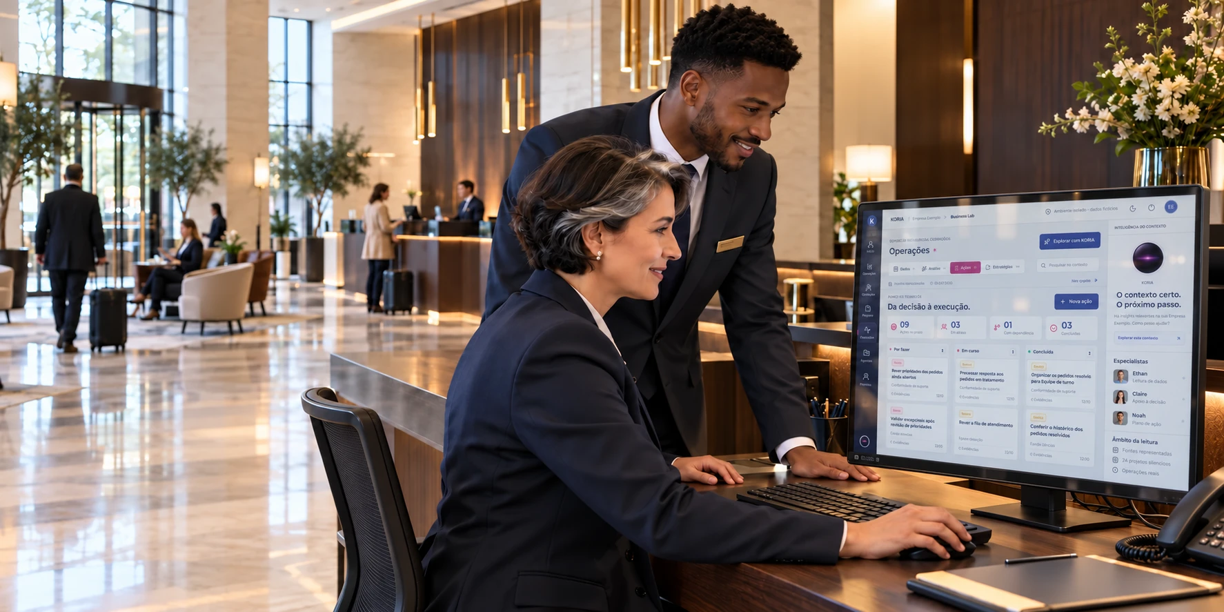 Colegas de receção de um hotel consultam o plano de ações do KORIA.